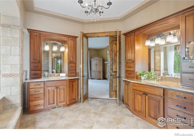 8236 County Road 74, Windsor, CO 80550 - bathroom featuring two vanities, a chandelier, tile patterned floors, and ornamental molding