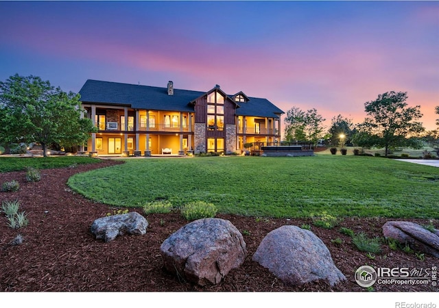 8236 County Road 74, Windsor, CO 80550 - back of property at dusk featuring a lawn, a balcony, and a chimney