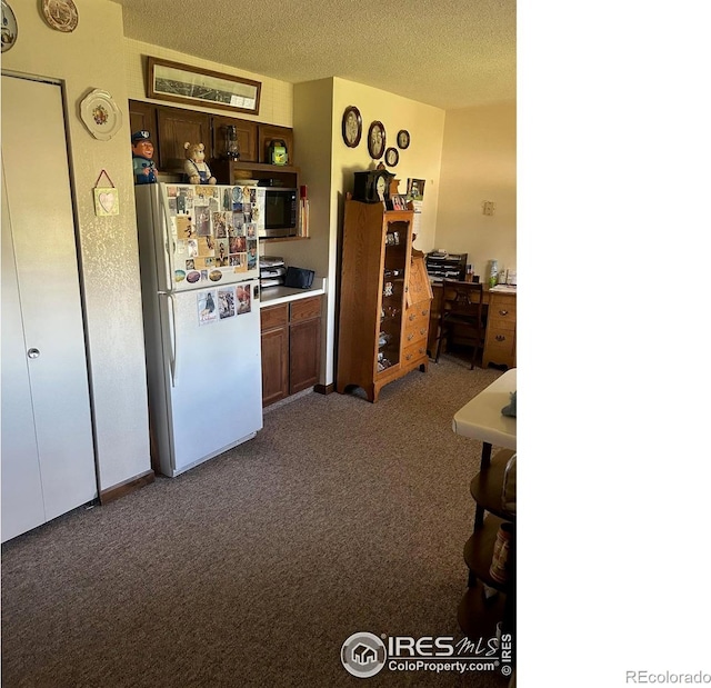 31888 County Road U, Brush, CO 80723 - kitchen featuring freestanding refrigerator, carpet flooring, a textured ceiling, light countertops, and dark brown cabinets