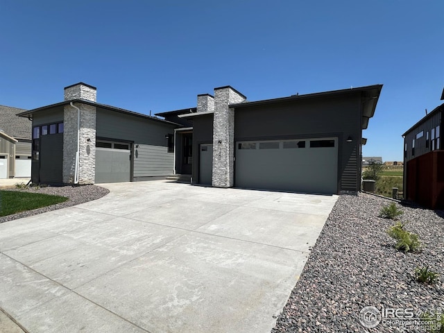 1647 Flourish Dr, Windsor, CO 80550 - modern home with an attached garage, a chimney, and driveway