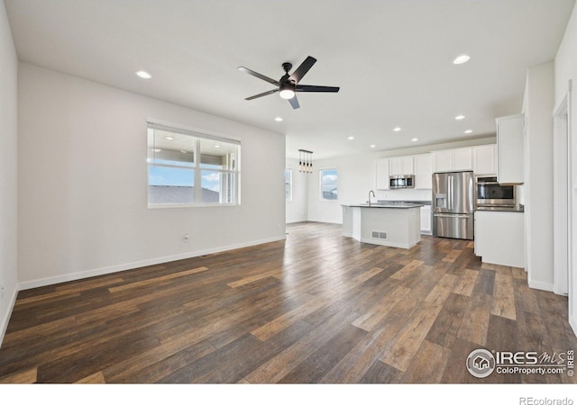 961 Mouflon Dr, Severance, CO 80550 - unfurnished living room featuring a sink, dark wood finished floors, recessed lighting, a ceiling fan, and baseboards