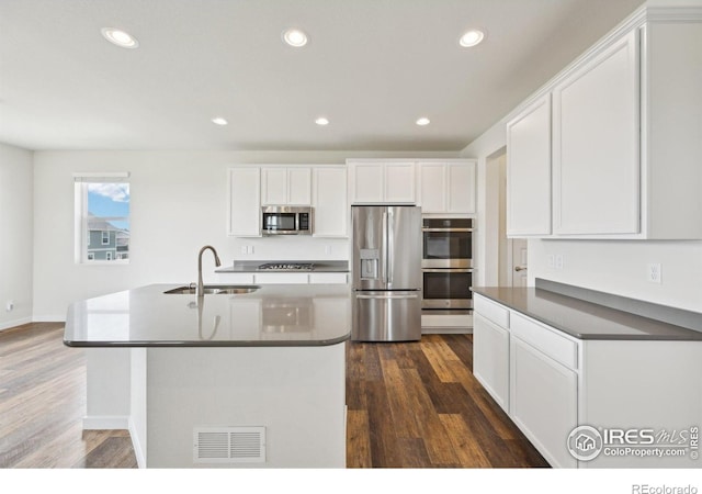961 Mouflon Dr, Severance, CO 80550 - kitchen featuring appliances with stainless steel finishes, a sink, dark wood-type flooring, recessed lighting, and white cabinetry