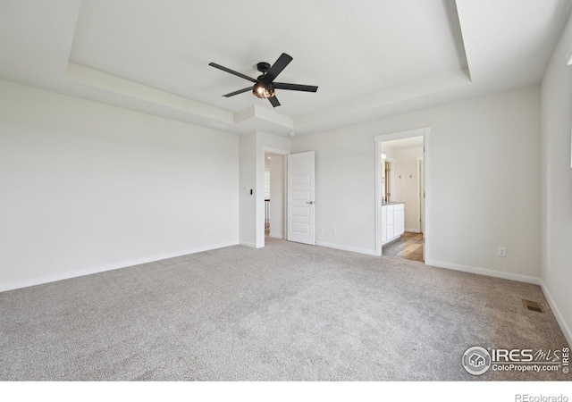 961 Mouflon Dr, Severance, CO 80550 - unfurnished bedroom with a tray ceiling, carpet floors, baseboards, and ensuite bathroom