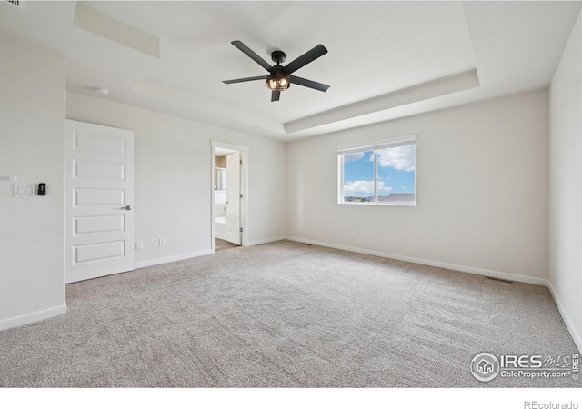 961 Mouflon Dr, Severance, CO 80550 - carpeted empty room with a tray ceiling, ceiling fan, and baseboards