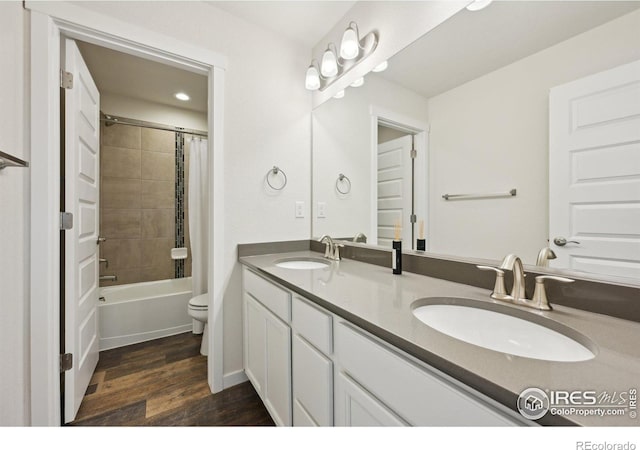 961 Mouflon Dr, Severance, CO 80550 - full bathroom featuring double vanity, wood finished floors, toilet, shower / bath combo with shower curtain, and recessed lighting