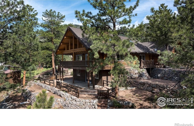 28 Ute Crossing Ct, Lyons, CO 80540 - view of front of house featuring a wooden deck, roof with shingles, a patio, and log siding