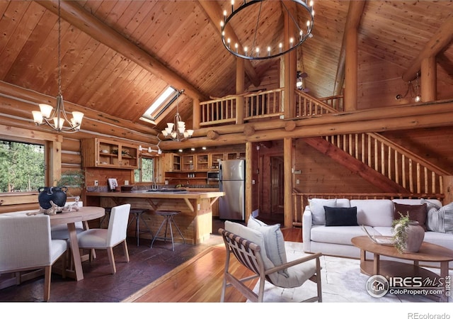 28 Ute Crossing Ct, Lyons, CO 80540 - living area featuring a chandelier, high vaulted ceiling, plenty of natural light, log walls, and wood ceiling with exposed beams