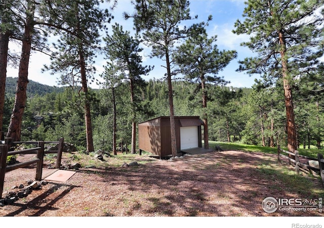 28 Ute Crossing Ct, Lyons, CO 80540 - view of yard featuring a forest view, a detached garage, and an outdoor structure