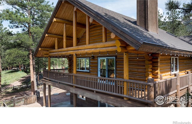 28 Ute Crossing Ct, Lyons, CO 80540 - rear view of property with log exterior, a chimney, roof with shingles, and a deck