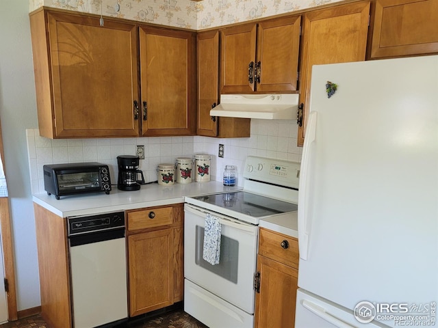 1918 Sumac Pl, Longmont, CO 80501 - kitchen with white appliances, under cabinet range hood, brown cabinetry, and light countertops