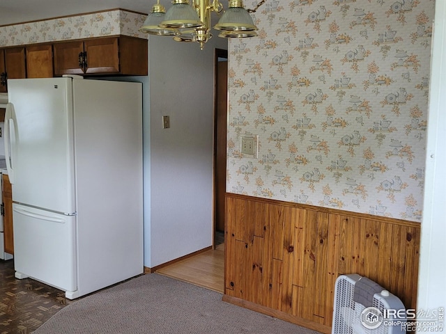 1918 Sumac Pl, Longmont, CO 80501 - kitchen featuring freestanding refrigerator, a wainscoted wall, wooden walls, a chandelier, and wallpapered walls