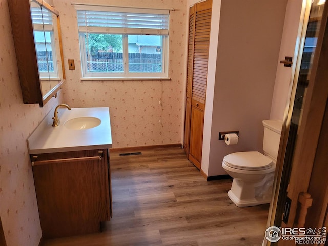 1918 Sumac Pl, Longmont, CO 80501 - bathroom featuring vanity, wood finished floors, toilet, and baseboards