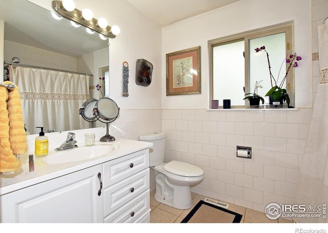 1405 Village Ln, Fort Collins, CO 80521 - bathroom with tile patterned flooring, tile walls, toilet, vanity, and a wainscoted wall