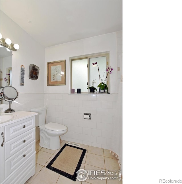 1405 Village Ln, Fort Collins, CO 80521 - bathroom with tile walls, tile patterned flooring, toilet, vanity, and a wainscoted wall