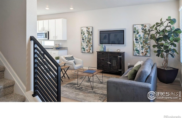 3356 Streamwood Dr, Johnstown, CO 80534 - living room with light wood-type flooring, recessed lighting, and stairway