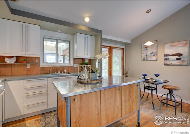 1110 Hartford Dr, Boulder, CO 80305 - kitchen with stainless steel counters, white cabinetry, backsplash, light wood finished floors, and vaulted ceiling