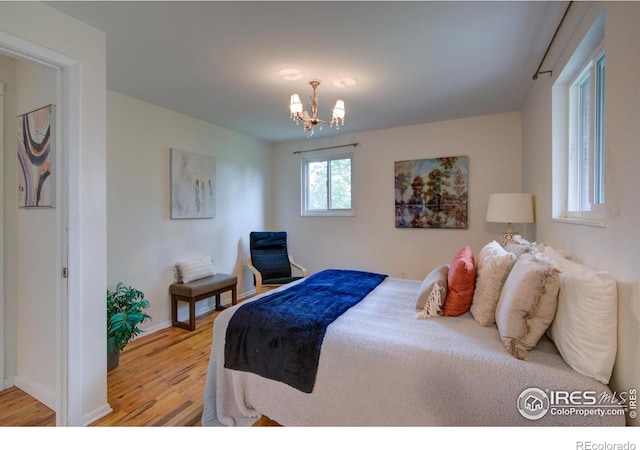 1110 Hartford Dr, Boulder, CO 80305 - bedroom with light wood finished floors, a chandelier, and baseboards
