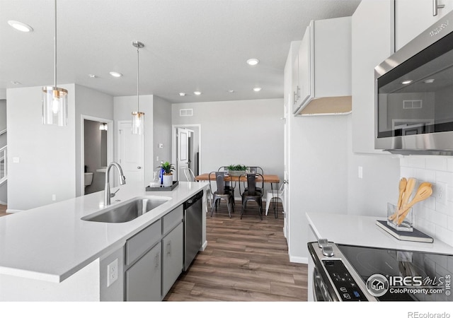 3364 Streamwood Dr, Johnstown, CO 80534 - kitchen featuring appliances with stainless steel finishes, dark wood-style flooring, recessed lighting, light countertops, and decorative light fixtures