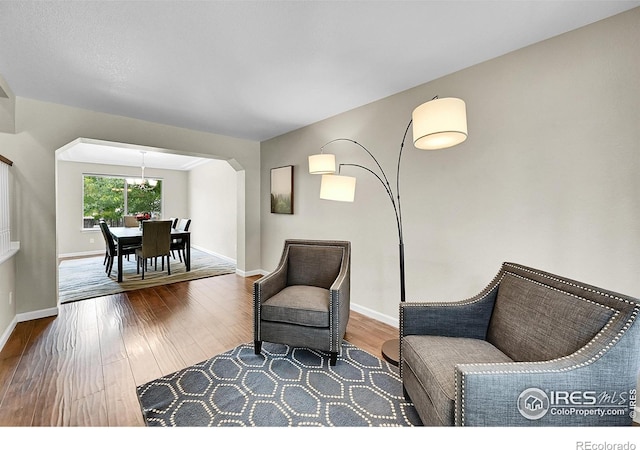 11740 Ivy St, Thornton, CO 80233 - living area with wood finished floors, a chandelier, baseboards, and arched walkways