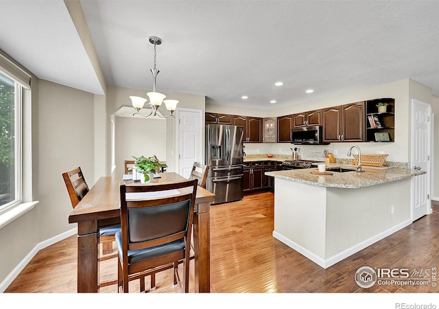11740 Ivy St, Thornton, CO 80233 - kitchen featuring appliances with stainless steel finishes, dark brown cabinets, a chandelier, light wood-type flooring, and recessed lighting