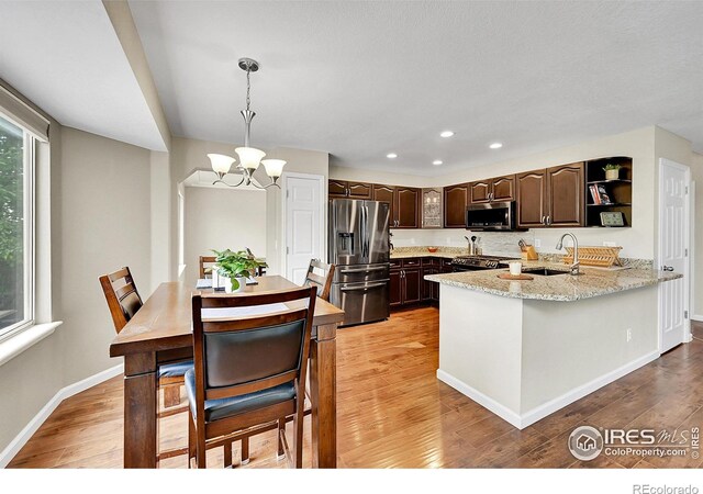 11740 Ivy St, Thornton, CO 80233 - kitchen featuring appliances with stainless steel finishes, dark brown cabinets, a chandelier, light wood-type flooring, and recessed lighting