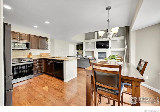 11740 Ivy St, Thornton, CO 80233 - kitchen with appliances with stainless steel finishes, dark brown cabinets, a sink, light wood finished floors, and recessed lighting