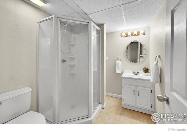 11740 Ivy St, Thornton, CO 80233 - full bathroom with vanity, a shower stall, toilet, tile patterned flooring, and a paneled ceiling