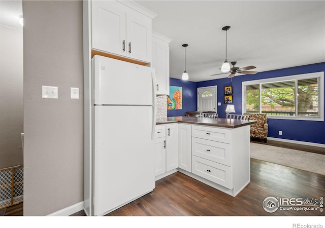 11385 Downing Dr, Northglenn, CO 80233 - kitchen featuring freestanding refrigerator, a peninsula, dark wood finished floors, dark countertops, and ceiling fan