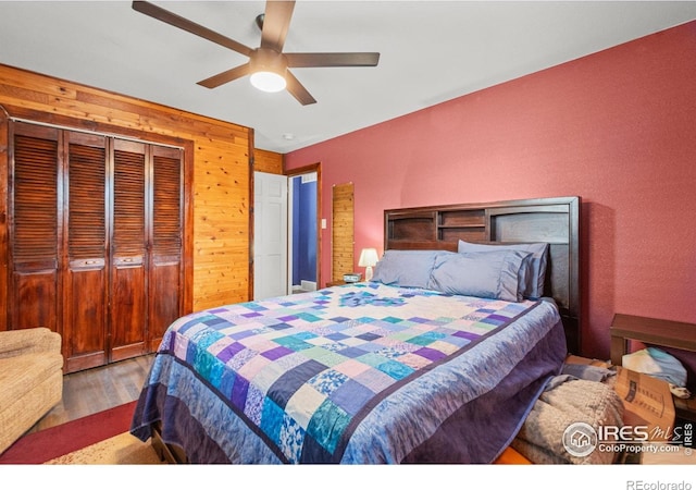 11385 Downing Dr, Northglenn, CO 80233 - bedroom featuring wood finished floors, wood walls, a closet, and a ceiling fan