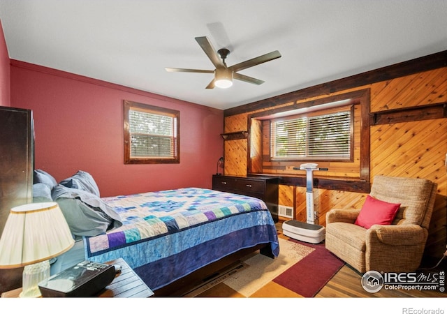 11385 Downing Dr, Northglenn, CO 80233 - bedroom with wooden walls, wood finished floors, and ceiling fan