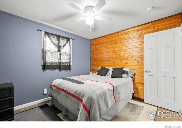 11385 Downing Dr, Northglenn, CO 80233 - bedroom with wooden walls, wood finished floors, baseboards, and a ceiling fan