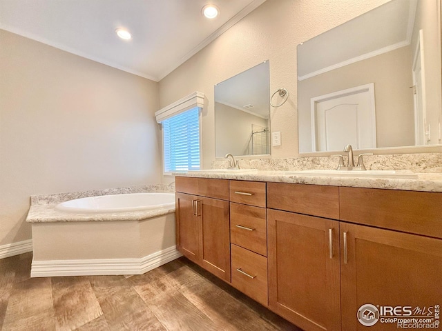 44502 County Road 68, Briggsdale, CO 80611 - full bathroom featuring double vanity, ornamental molding, a garden tub, baseboards, and wood finished floors