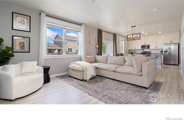 929 Charlton Dr, Windsor, CO 80550 - living room with a chandelier, light wood finished floors, baseboards, and recessed lighting