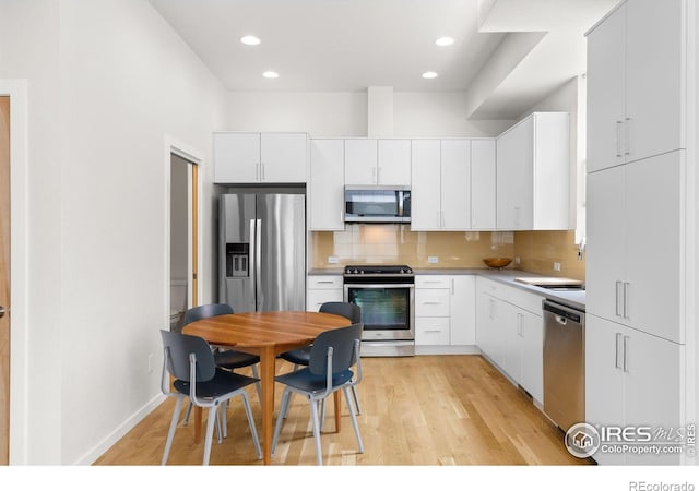 876 Cimarron Dr Unit B, Lafayette, CO 80026 - kitchen featuring stainless steel appliances, decorative backsplash, light wood-style flooring, white cabinets, and recessed lighting