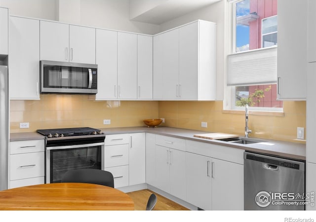876 Cimarron Dr Unit B, Lafayette, CO 80026 - kitchen featuring stainless steel appliances, light countertops, a sink, and white cabinets