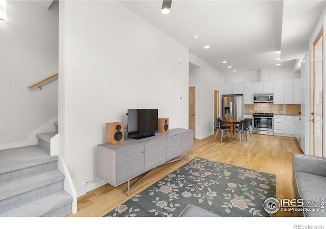 876 Cimarron Dr Unit B, Lafayette, CO 80026 - living room with light wood finished floors, stairway, recessed lighting, and baseboards