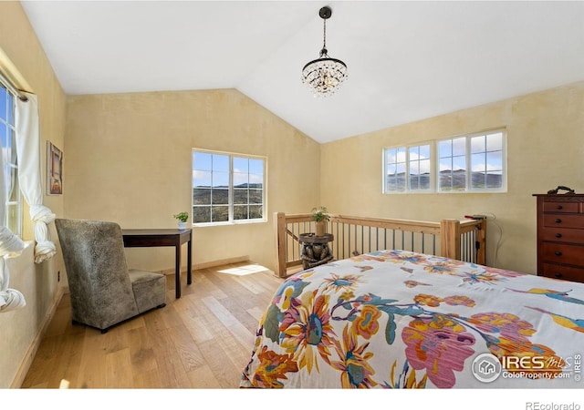2507 Spencer Mountain Rd, Bellvue, CO 80512 - bedroom with wood finished floors, multiple windows, lofted ceiling, a chandelier, and baseboards