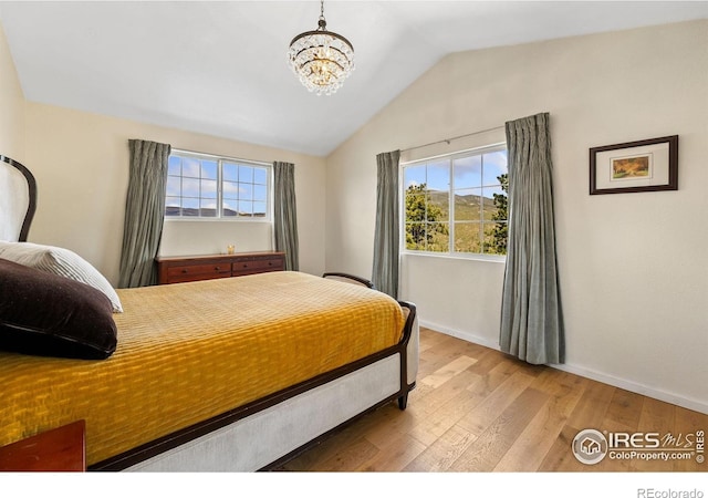 2507 Spencer Mountain Rd, Bellvue, CO 80512 - bedroom featuring vaulted ceiling, light wood-type flooring, baseboards, and a chandelier