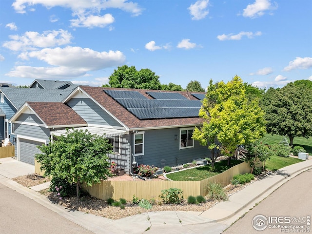 603 Summer Hawk Dr, Longmont, CO 80504 - view of front of home with roof mounted solar panels, a shingled roof, concrete driveway, and a garage