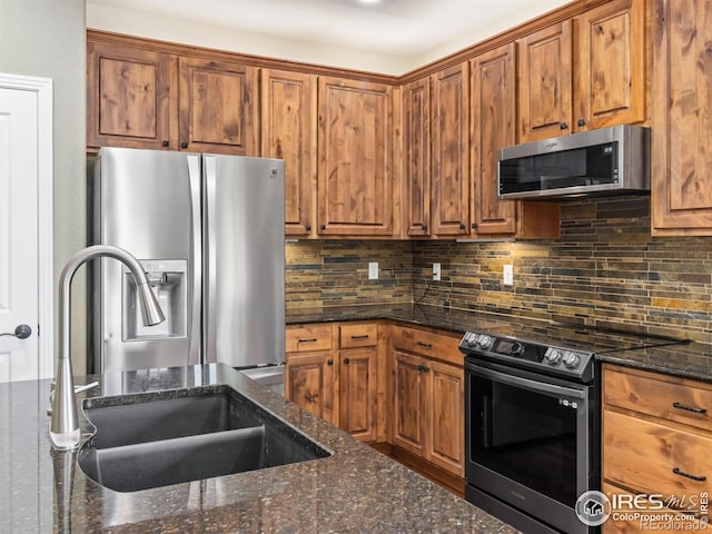 603 Summer Hawk Dr, Longmont, CO 80504 - kitchen with stainless steel appliances, a sink, brown cabinetry, and tasteful backsplash