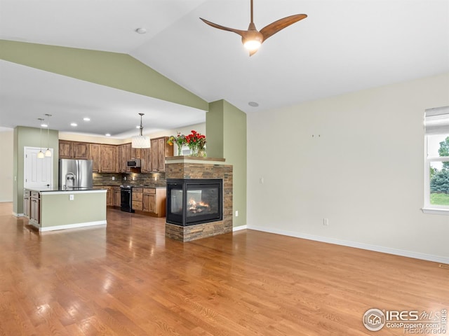 603 Summer Hawk Dr, Longmont, CO 80504 - unfurnished living room featuring lofted ceiling, wood finished floors, a ceiling fan, and baseboards