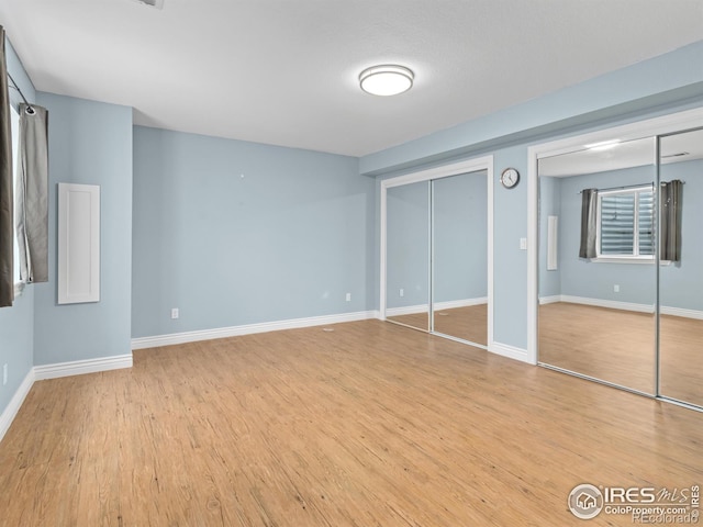 603 Summer Hawk Dr, Longmont, CO 80504 - unfurnished bedroom featuring multiple closets, light wood finished floors, and baseboards