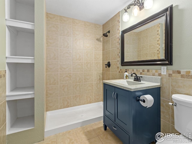 603 Summer Hawk Dr, Longmont, CO 80504 - full bathroom with tile walls, tiled shower, tile patterned flooring, vanity, and toilet
