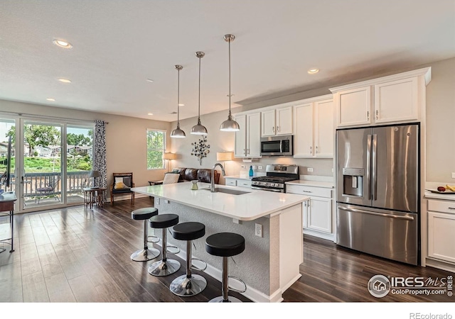 4343 E 96th Way, Thornton, CO 80229 - kitchen featuring stainless steel appliances, a sink, dark wood-style flooring, a breakfast bar, and light countertops