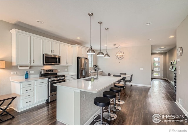 4343 E 96th Way, Thornton, CO 80229 - kitchen featuring stainless steel appliances, a sink, dark wood-style flooring, a center island with sink, and recessed lighting
