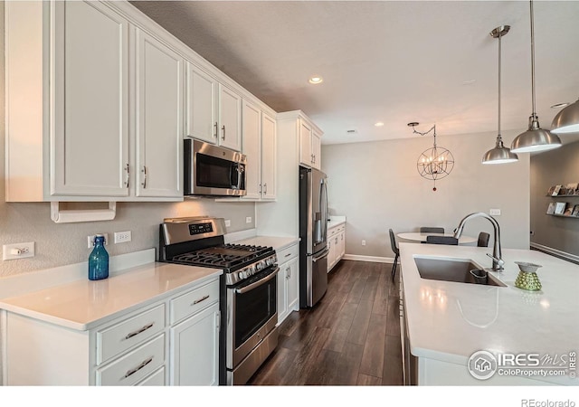 4343 E 96th Way, Thornton, CO 80229 - kitchen with stainless steel appliances, a sink, a chandelier, white cabinets, and dark wood-style floors