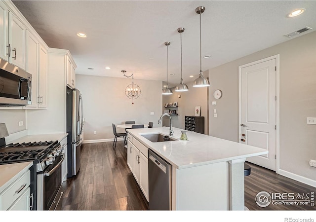 4343 E 96th Way, Thornton, CO 80229 - kitchen featuring stainless steel appliances, a sink, dark wood-type flooring, baseboards, and a chandelier
