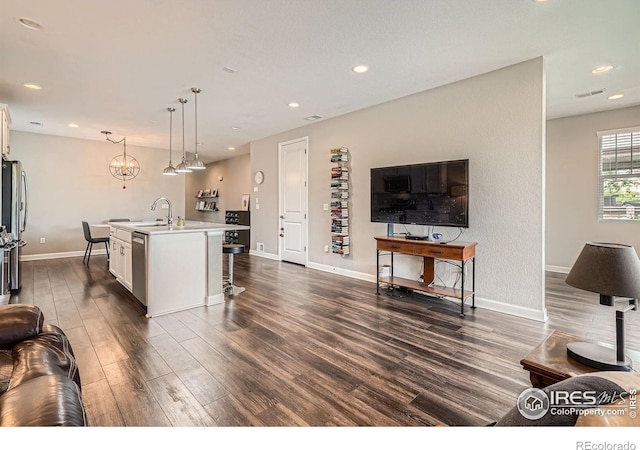 4343 E 96th Way, Thornton, CO 80229 - living area featuring dark wood finished floors, baseboards, recessed lighting, and a chandelier