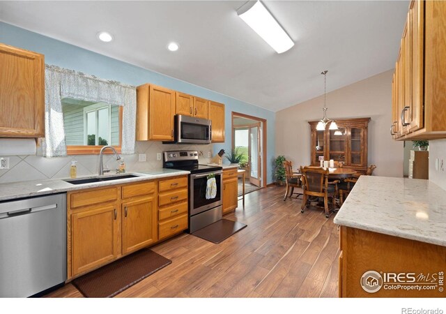 32924 County Road 29, Greeley, CO 80631 - kitchen featuring appliances with stainless steel finishes, a sink, light wood-style floors, lofted ceiling, and decorative backsplash