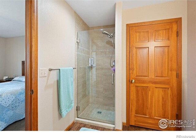 32924 County Road 29, Greeley, CO 80631 - ensuite bathroom with a shower stall, baseboards, and wood finished floors